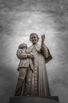 Sculpture of a priest who shows the way to a child.