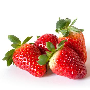 Four ripe strawberries on a white background.