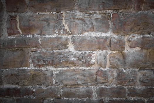 Front view of a stone wall slightly illuminated.