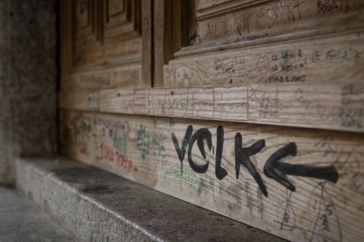 An old door covered with writing of any kind.