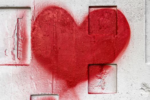 A red heart painted with love on a wall.