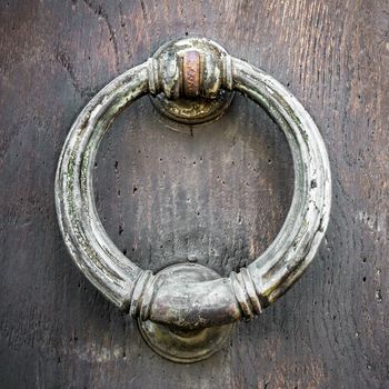 Ancient knocker brass ring on a wooden door