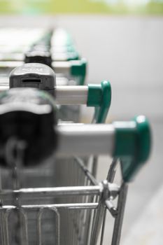 Green shopping carts in the parking lot of a supermarket