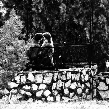 Teenagers in love kissing on a bench in park of Orsova, Romania, 2020.
