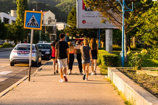 Group of teenagers walking on a street in Orsova, Romania, 2020