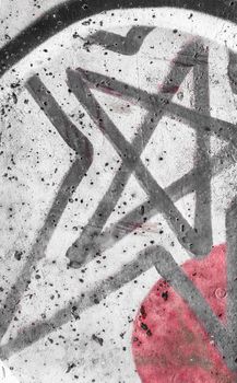 A grunge star painted on the wall with spray paint. Under a red circle. Ideal for concepts and backgrounds.