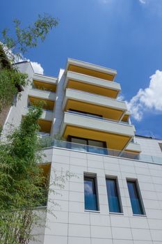 Modern apartments with balconies and blue sky in the background