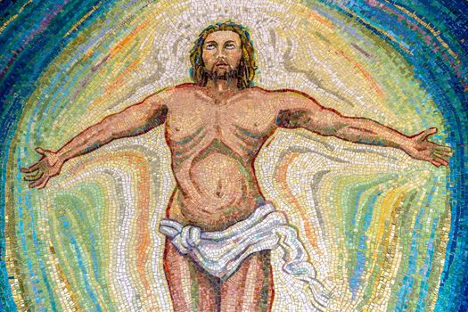 Religious mosaic of Jesus Christ, with open arms and eyes to the sky. The painting is multicolored. It can be used for backgrounds or concepts.