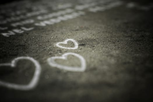 Three hearts painted on the asphalt.