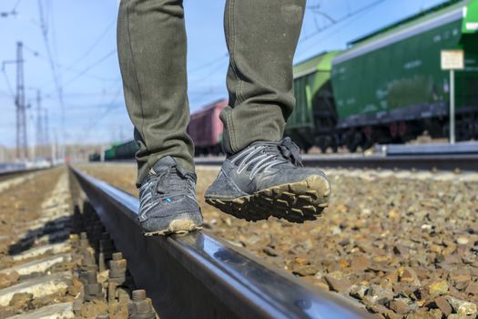 A free man walking on a railroad track in dirty shoes and pants