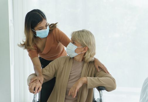 happy senior mother and daughter wearing protective mask, having fun at home.  family of diverse skin. Concept of love sharing time Care for Grandmother, mother, daughter, granddaughter, and adoption