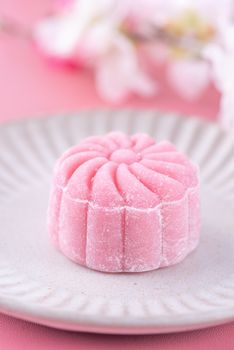 Colorful snow skin moon cake, sweet snowy mooncake, traditional savory dessert for Mid-Autumn Festival on pastel pale pink background, close up, lifestyle.