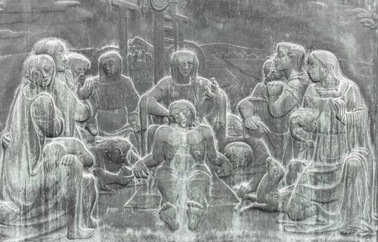 Stone wall engraving scene depicting the Lamentation of Christ