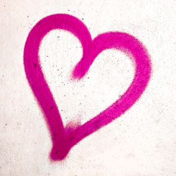 Pink heart shaped on grungy wall background. Metaphor to urban and romantic Valentine, grungy style.