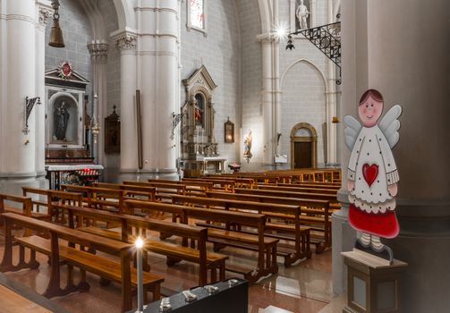 A cute little cardboard angel decorates an empty church. Ideal for concepts and holidays.