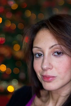 Portrait of beautiful young girl with long hair on a christmas background with bokeh lights. Defocused blurry background.