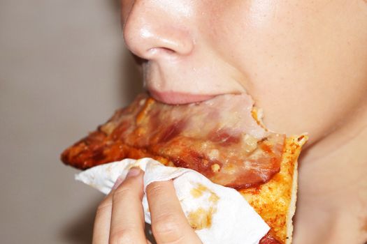 teenage girl eating pizza with sausage