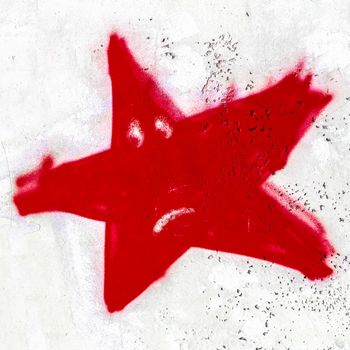 A red sad star painted on the wall with spray paint.