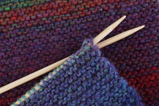 Knitting with wood needles and colorful wool yarn
