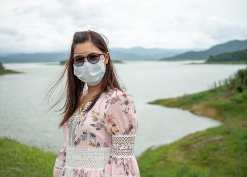 Portrait of a woman wearing a protective mask On the background as a tourist attraction.