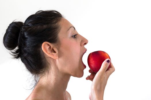 A girl while eating a peach, isolated on white background.