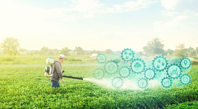 A farmer with a mist blower on potato plantation and technological innovation gears hologram. Using science and technology in agriculture to improve the efficiency and productivity of food production.