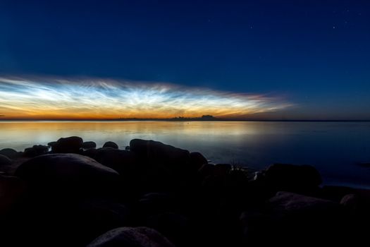 Dawn on the lake. Feathered clouds glow at dawn.