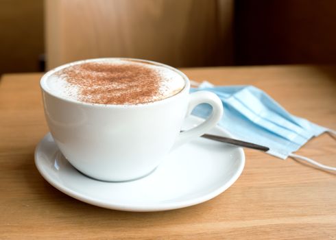 cup of coffee and face mask on the table