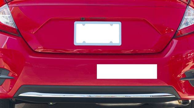 Horizontal shot of the rear of a red car with a blank white license plate and bumper sticker.  Good copy space.