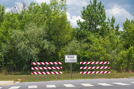 Horizontal shot of a road closed sign on new highway construction.