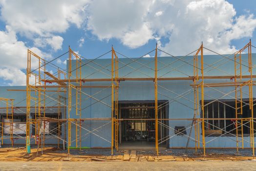 Horizontal shot of scaffolding surrounding a new commercial building under construction.