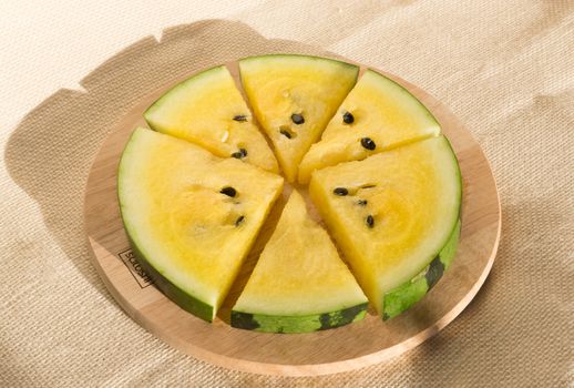 Yellow watermelon cut into wedges for the watermelon diet. Circle of watermelon slices