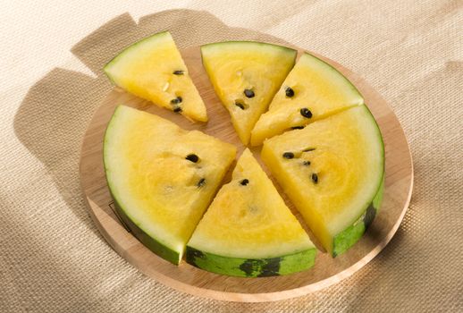 Yellow watermelon cut into wedges for the watermelon diet. Circle of watermelon slices