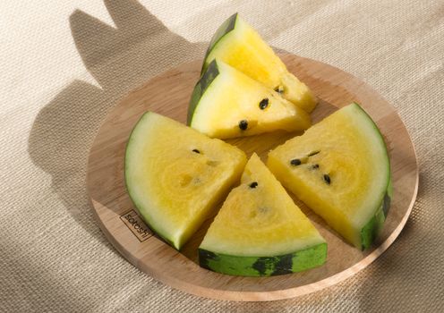 Yellow watermelon cut into wedges for the watermelon diet. Circle of watermelon slices