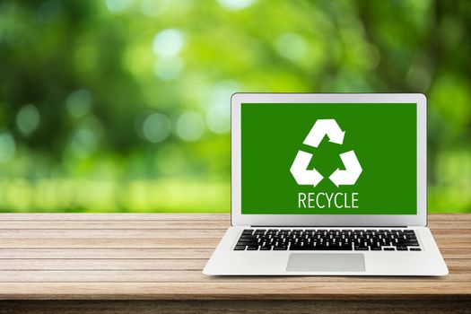 Environment conservation with recycle green icon of labtop on nature background, notebook with table top, environmental conservation concept.
