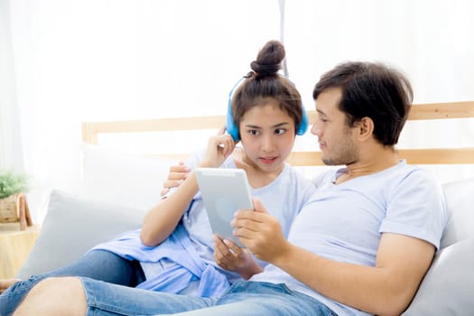 Beautiful asian young couple listening to music with tablet on bed, Love, dating,Young couple in sitting together in bed using a Tablet.
