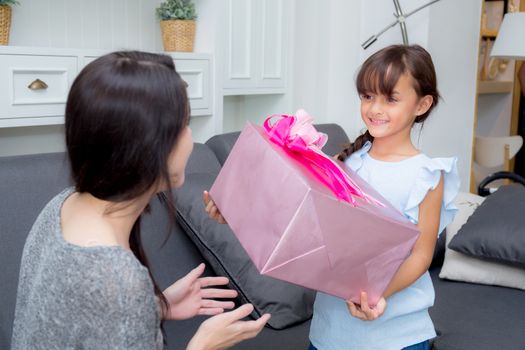 happy of mother and daughter asian with gift with pink ribbon and daughter kissing mother, Happy family concept. Happy mother's day.