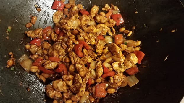 Chinese food chicken and peanuts and red peppers in wok