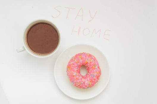 Top view,A cup of cacao drink and one glazed pink donut on white background.Sweet dessert.Stay home in warm.