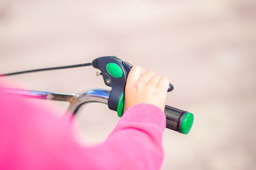 Children's bicycle handlebar with hand brake. The child presses the hand brake. Security