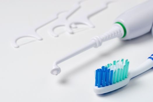 Toothbrush, tartar removal device, and floss on a white background. High quality photo