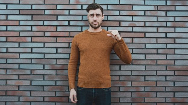 young man hipster holding something small in his hands and smiling.