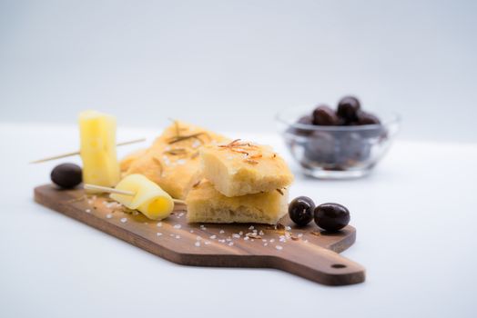 Italian focaccia with onion, olives and cheese over a cutting board