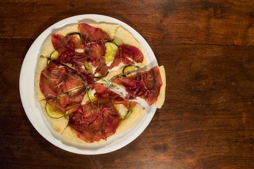 Italian pizza with bresaola, zucchini and eggplant seen from above