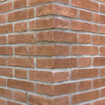 Front view of a wall with bricks arranged in a regular mode.