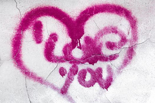 A big heart with love message painted on a wall with spray.
