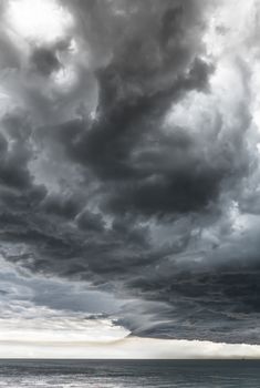 Landscape photo of a beach and dramatic thunderstorm clouds over the sea or the ocean