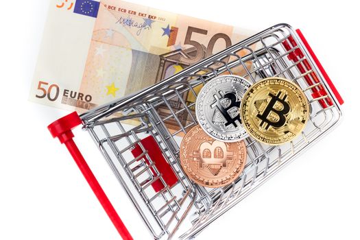 Financial concept with image of bitcoins in shopping cart on fifty euro banknote. Traditional money versus cryptocurrency concept.