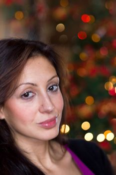 Portrait of beautiful young girl with long hair on a christmas background with bokeh lights. Defocused blurry background.