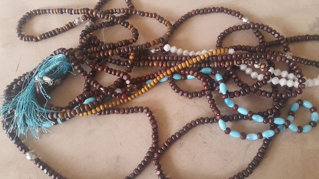 Beautiful wooden prayer beads or rosary placed over fabric background. Religion concept of ramadan or Eid for muslims.